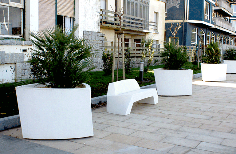 Escofet Bilbao Plantenbak en zitbank Witte gewapend betonnen plantenbakken en zitbank in een stedelijke setting, ontworpen voor parken en publieke ruimtes.