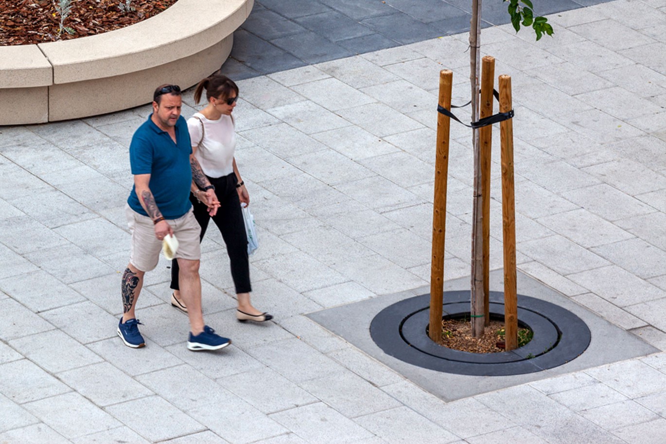 Boomrooster met ringen Carmel van Escofet 1886 by Molins Boomkader van gietaluminium langs wandelpad in moderne publieke ruimte, beschermt tegen mechanische schade.
