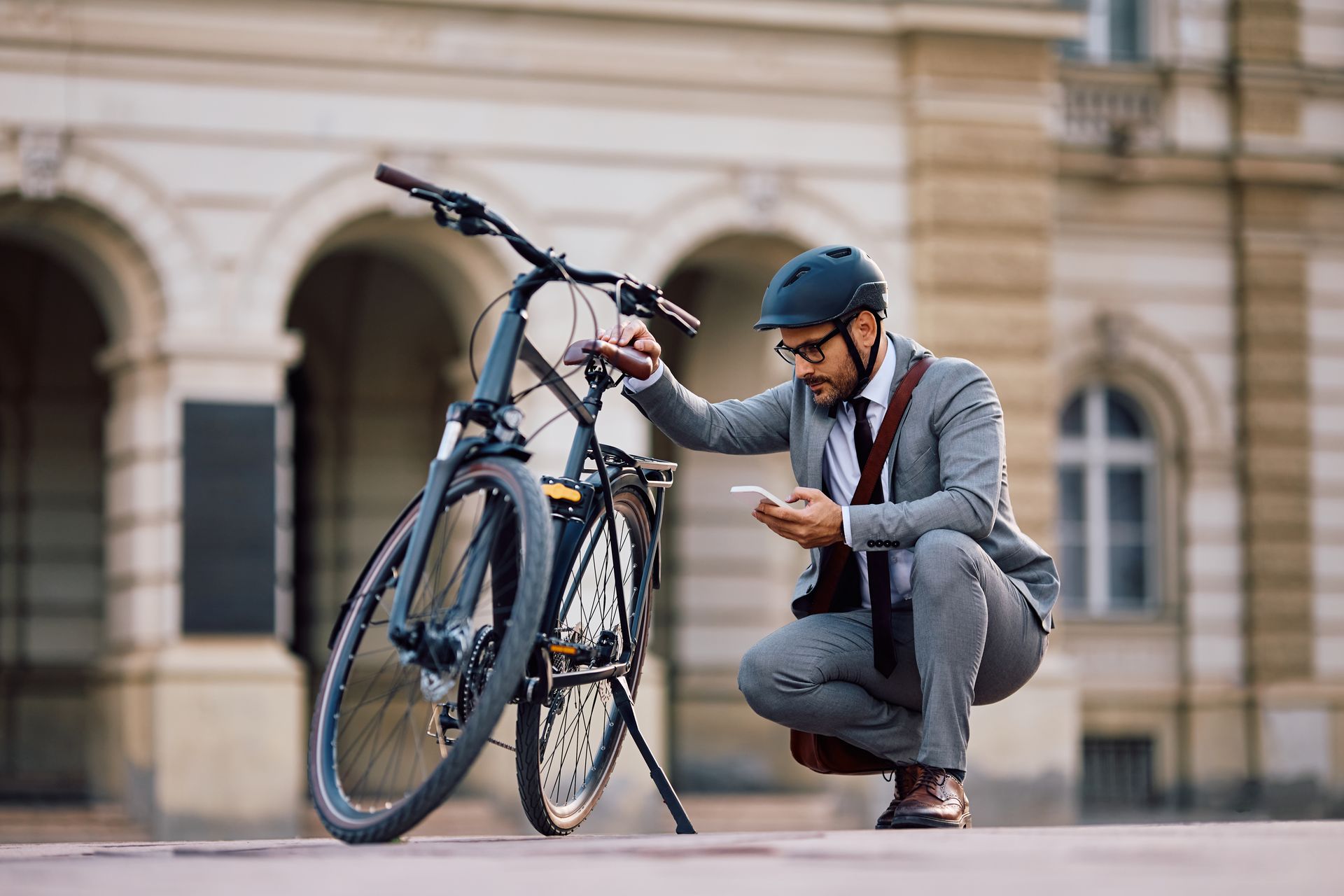 Zakelijke fietser controleert zijn fiets op problemen in de stad – Slimme fietsreparatie en onderhoud voor forenzen in openbare ruimte