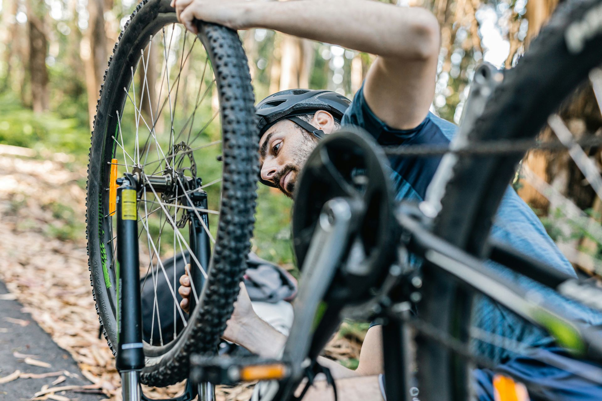 Mountainbiker repareert voorwiel in bos – Openbare fietsherstelpunten voor snelle reparaties onderweg
