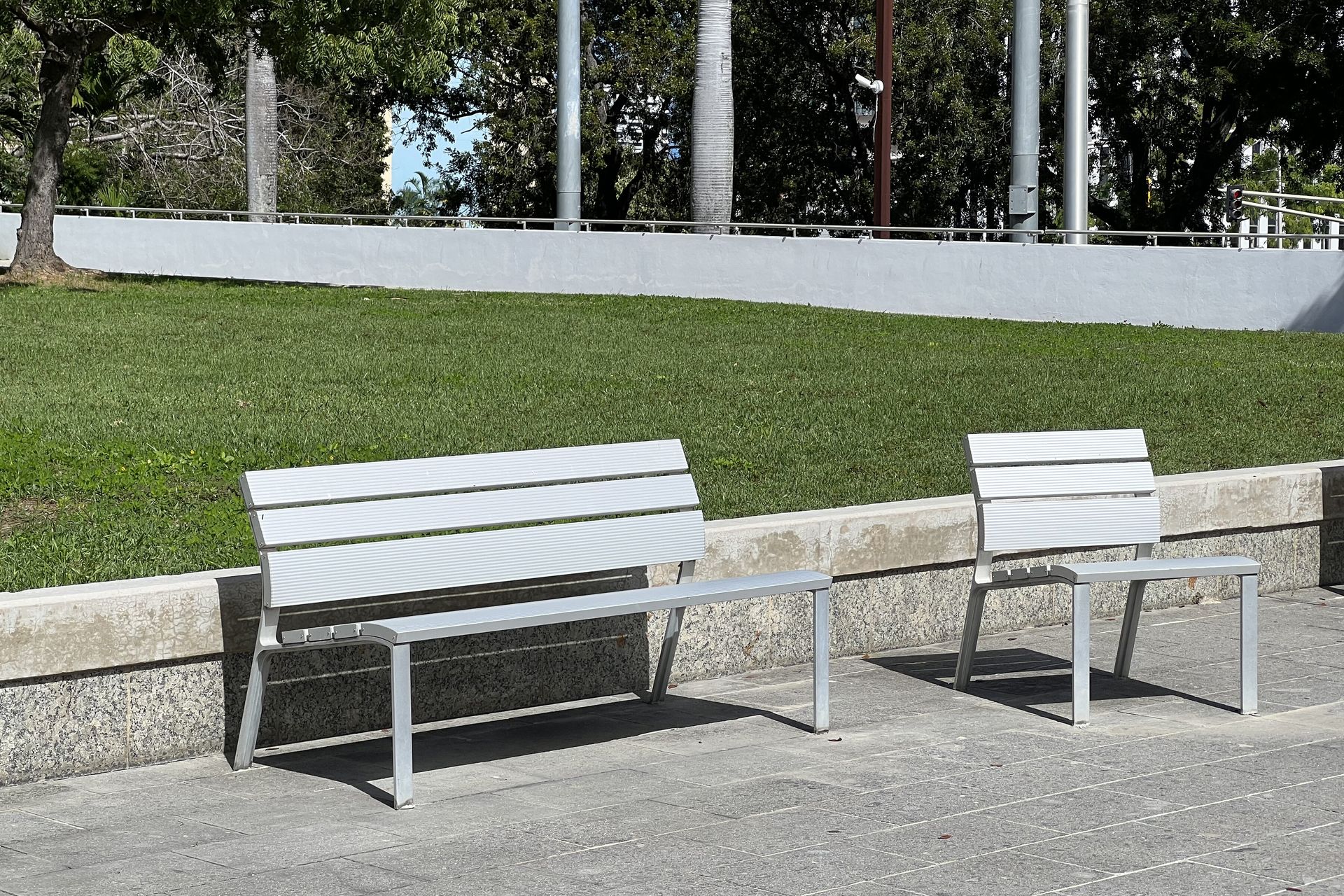 De Urbidermis Neoromantico Liviano zitbanken in aluminium Circulair ontworpen aluminium zitbank en stoel van Urbidermis in stedelijke groene omgeving, ideaal voor duurzame openbare ruimte.