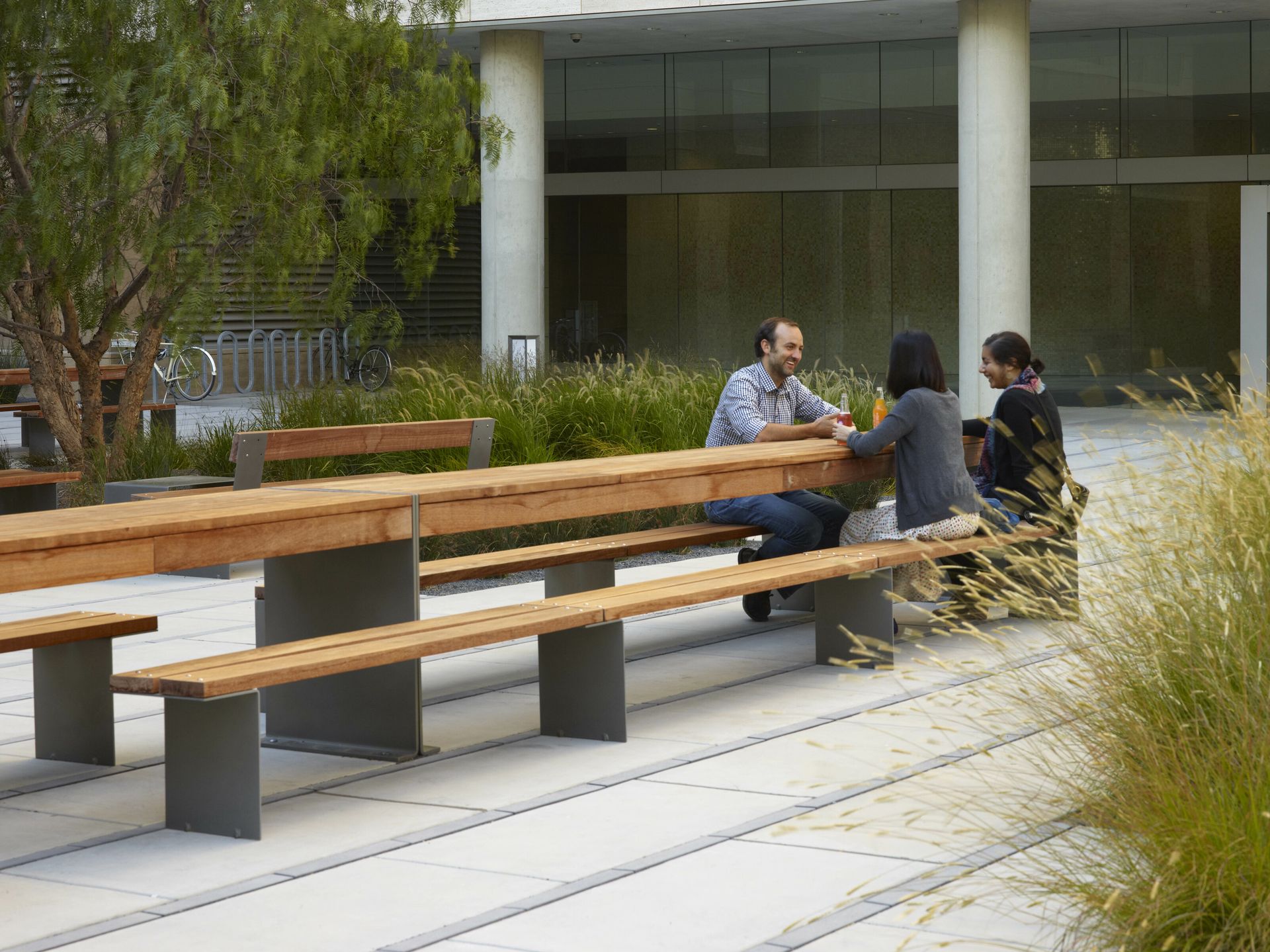 De Urbidermis Bancal picknick set Mensen ontmoeten elkaar aan picknickbanken van Urbidermis in een circulair ingerichte stedelijke buitenruimte.