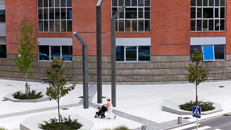 Zitbanken en boomroosters op modern plein met stedelijke bebouwing – circulair straatmeubilair in actie