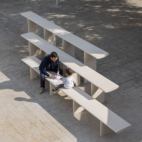 Escofet Tiers à trois hauteurs, avec un père et un enfant assis et dessinant sur le banc le plus bas dans un cadre urbain.