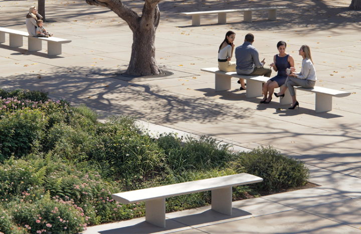 Bancs modulaires Tiers d’Escofet dans un jardin urbain paysager, utilisés par des usagers en conversation à l’ombre des arbres.