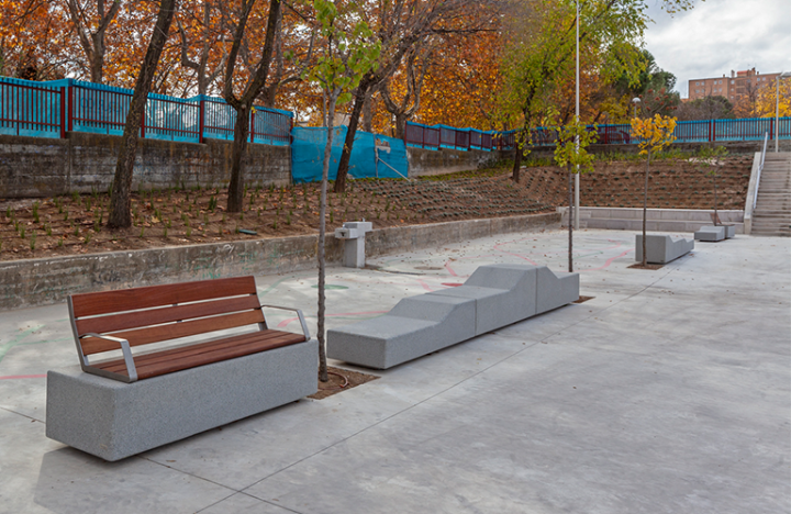 Overzicht van Escofet Kanji zitbanken langs bomenrij in stedelijk park, versterking van publieke ruimte door ergonomisch meubilair.