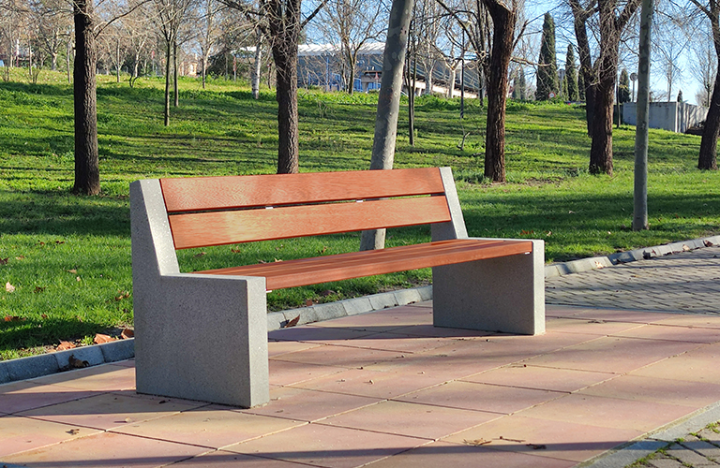 Close-up Alpine buitenbank: houten zit- en ruglatten op betonnen steun, sobere afwerking voor park en openbare ruimte