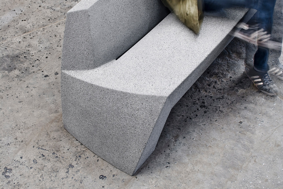 Detail van de Bilbao bank van Escofet 1886 in grijs gewapend beton, met organische zitting, lage rugleuning en smalle waterafvoer tussen zitvlak en rug.