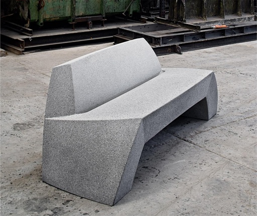 Bilbao bank van Escofet 1886 in grijs gewapend beton, met lage rugleuning en organische vormgeving geïnspireerd op een uit rots gesneden zitobject.